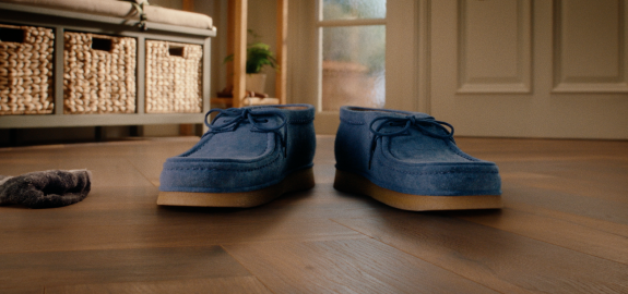 Tim & Tom, a pair of blue suede loafers on a laminate floor